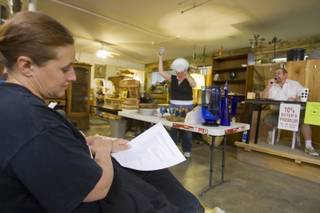 Linda Dennen looks at her listing of items to bid on, during a monthly antiques auction at the Boulder City Antique Mall.