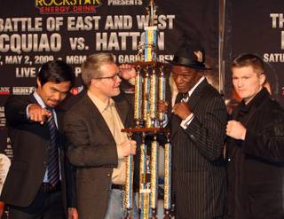 Boxers Manny Pacquiao, far left, of the Philippines, and Ricky Hatton, far right, of England, pose with their trainers Freddie Roach, center left, and Floyd Mayweather Sr., who lift a specialized trophy for the 
