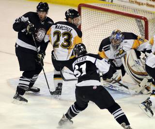 Wranglers forward Adam Miller (right) sends a shot off the backside off Thunder defenseman Daryl Marcoux as Scott McCulloch looks for a rebound in front of Stockton netminder Andrew Perugini during a game at the Orleans on Friday night.