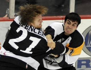 Wranglers pugelist Tim Spencer (left) takes a right from Thunder winger Adam Huxley in a one-sided bout during a game at the Orleans Arena on Friday night.