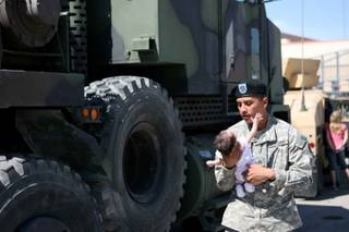 Spc. Adalberto Martinez, 33, holds up his one-month-old daughter, Kaitlyn, during their last hours together following a mobilization ceremony for the 1864th Transportation Company Thursday at the Nevada Army National Guard Floyd Edsall Training Center.