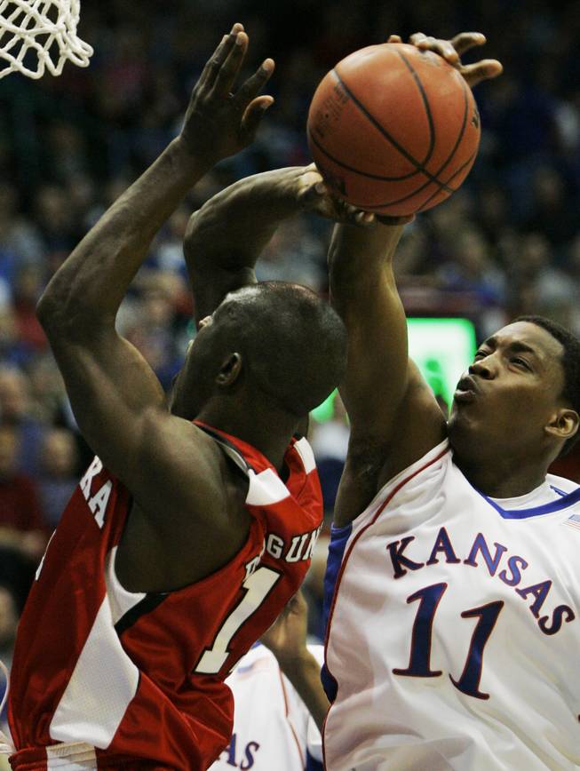 Kansas forward Quintrell Thomas, right, blocks a shot by Nebraska guard Ade Dagunduro (11) during the second half of their game in Lawrence, Kan., on Feb. 21, 2009. Kansas defeated Nebraska 70-53.