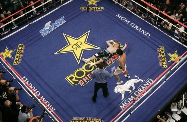 Manny Pacquiao, right, of the Philippines, walks to his corner after he knocked down British boxer Ricky Hatton, center, in the second round of their junior welterweight title boxing match Saturday, May 2, 2009, at the MGM Grand in Las Vegas. Pacquiao won by TKO in the second round.