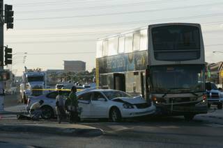 Young pedestrians wait to cross the street at the scene of an accident between multiple cars and a bus at the intersection of Boulder Highway and Russell Road on Friday.