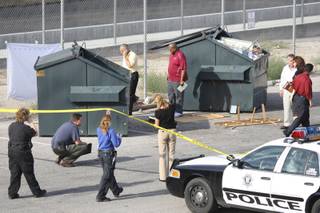 Metro Police officers investigate after a dead baby was discovered in a trash bin Wednesday behind the Kona Loha Sierra apartment complex.