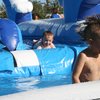 Alex Lee, 6, emerges from the water after a trip down the inflatable slip-and-slide at the Henderson Fourth of July festivities. 