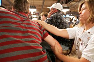 Massage therapist Paula Steiner works on a player during the World Series of Poker Main Event at the Rio.