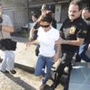 Photo: Amanda Rodrigues, center, is escorted by police of Photo: Amanda Rodrigues, center, is escorted by police of