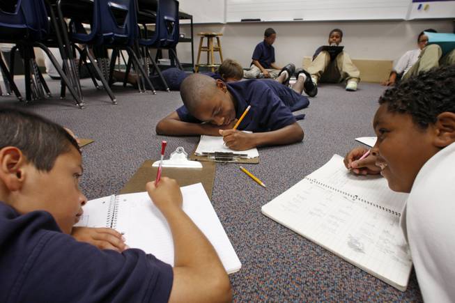 Diaz fifth graders Cristian Sanabria, left, Savion Jones, center, and Jaswaun Toney work on a writing project. 