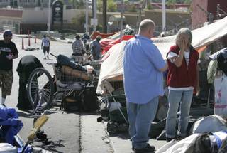 Rich Penska of H.E.L.P. of Southern Nevada, and a member of the Mobile Crisis Intervention Team, talks with a woman on Foremaster Lane Wednesday, July 29, 2009.  