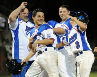Legacy Little League's Matt Almodovar is greeted by teammates after hitting a three-run, game-ending home run to give Nevada a 12-9 come from behind win over Arizona Wednesday night August 12, 2009, during the final game of pool play at the Western Regional Tournament at Al Houghton Stadium in San Bernardino.