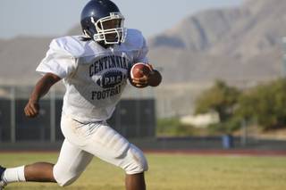 Quarterback Chris Henderson carries the ball while running offensive drills Monday during practice at Centennial High School.