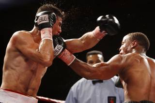 Marcos Mendias, left, of Phoenix takes a punch from Lawrence Hughes of Las Vegas during a junior welterweight bout at the Orleans on Friday. Hughes won the four-round fight.