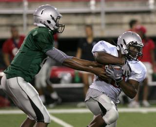 UNLV running back Bradley Randle takes a handoff from fellow freshman Caleb Herring during Saturday's closed team scrimmage at Sam Boyd Stadium.