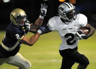 Panthers running back Chappell Thomas (2) stiff arms Grizzly defender Khoa Nguyen (2) during the season opener at Spring Valley High School on Friday.