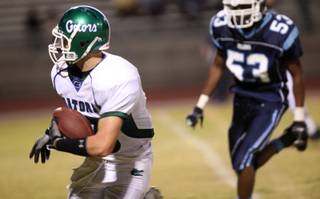 Green Valley High receiver Bryan Bello looks for space to run with Centennial linebacker Antar Rowlette giving chase Friday night at Centennial High School.  Green Valley edged out a win 10-7.