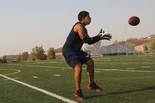Sophomore running back Charlie Pachas looks for the catch Monday during practice at Henderson International School.