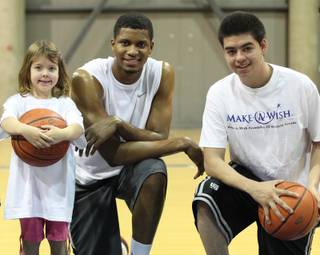 Armando Corral 17, and Erica Nichols, 5, play with a number of athletes in an event put on by Impact Sports and the Make-A-Wish Foundation Wednesday.  Here they posed for a photo with Rudy Gay of the Memphis Grizzlies.