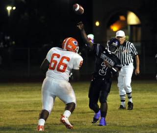 Durango High quarterback Greg McKinney lets a pass go while being pressured by Gorman defender Tim Wilkinson (66) during a game at Durango High School on Friday night.