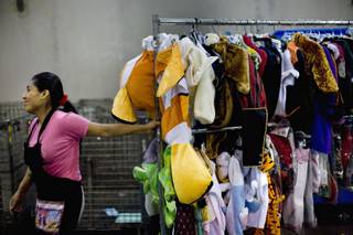 Maria Cruz pulls a rack of Halloween costumes into their designated area at Goodwill of Southern Nevada's processing center in North Las Vegas on Thursday, Sept. 3, 2009.  