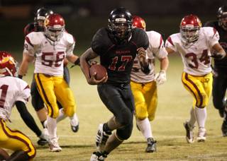 Hassan Henderson of Las Vegas runs past the Del Sol line for a huge gain during the Thursday night game against Del Sol at Las Vegas High. Del Sol won a close one 33-28.
