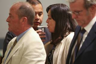 With her attorneys Jack Howard and John Watkins, right, at her side, former Boulder City Councilwoman Karla Burton blows a .115 blood-alcohol content during her court-mandated breathalyzer test. Burton appeared before Justice of the Peace Nancy Oesterle on Tuesday afternoon in connection with her arrest Feb. 6, 2007, on a felony drunken driving charge.
