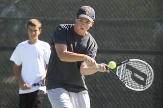 Boulder City High tennis player Sean Hickey attempts a backhand shot during a recent practice. Hickey is joined on the Eagles team with his brother, Brent Hickey.