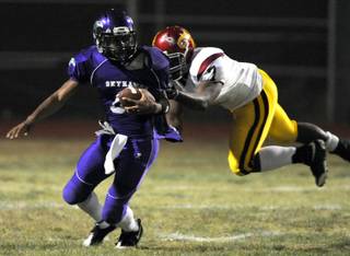 Skyhawks quarterback Trenten Tipton attempts unsucessfully to evade Dragons tackler Dezerick Reed, and is sacked on the play during a game at Silverado High on Friday night.