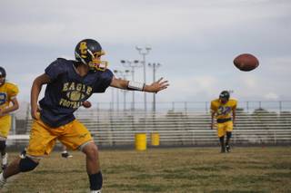 Senior quarterback Ross Lamarca pitches the ball while running offensive drills during practice at Boulder City High.
