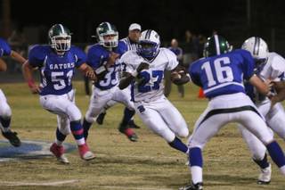 Basic running back Edward Villaros finds a hole as Green Valley defenders are left in the backfield Thursday during the Henderson Bowl game at Green Valley.