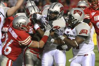 UNLV's Channing Trotter, center, breaks free for a touchdown against New Mexico on Saturday in Albuquerque, N.M.  UNLV won 34-17.