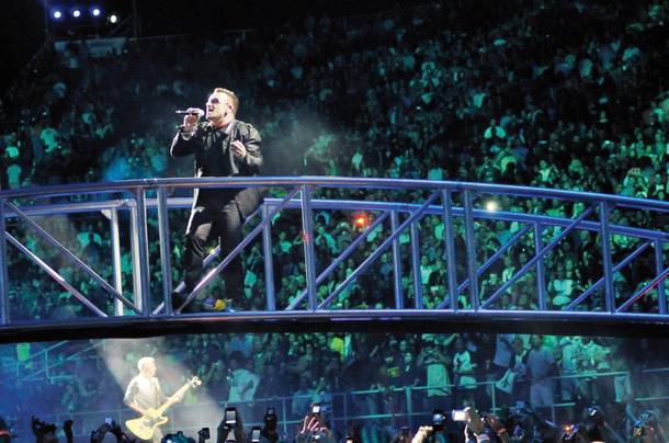 Bono, the lead singer of U2, performs from a bridge over the crowd Friday at Sam Boyd Stadium as part of the band's 360 Tour.