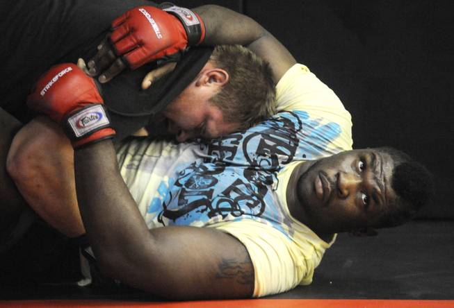 Brett Rogers, right, listens to advice from trainer Mike Reilly while rolling with training partner Kevin Asplund at Ambition Training Academy in Eagan, Minn. on Oct. 29, 2009.
