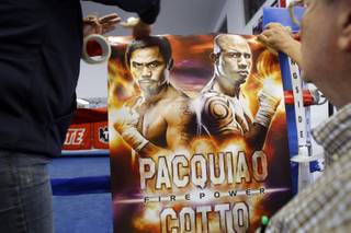 Ana Garcia, left, and Bill Caplan set up a poster before Miguel Cotto's media workout at the Pound4Pound Gym in Los Angeles on Tuesday, Nov. 3, 2009. Cotto, a WBO welterweight champion of Puerto Rico, is scheduled to defend his title against Manny Pacquiao of the Philippines at the MGM Grand Garden Arena on Nov. 14. 