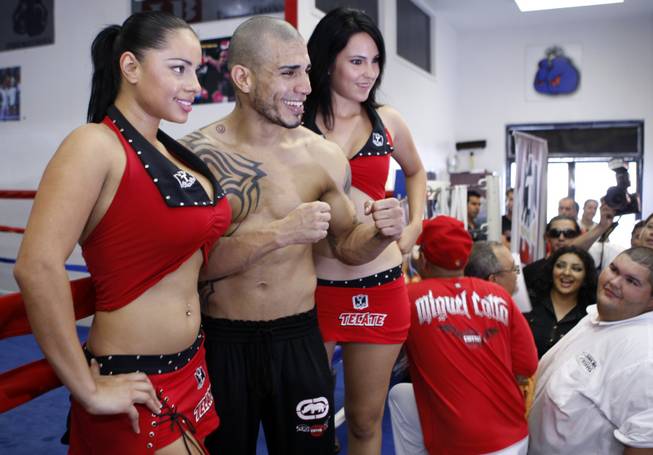 WBO welterweight champion Miguel Cotto of Puerto Rico poses with Tecate Girls Elena Diaz, left, and Natalie Gomez following a workout for the media at the Pound4Pound Gym in Los Angeles on Tuesday, Nov. 3, 2009. Cotto is scheduled to defend his title against Manny Pacquiao of the Philippines at the MGM Grand Garden Arena on Nov. 14. 