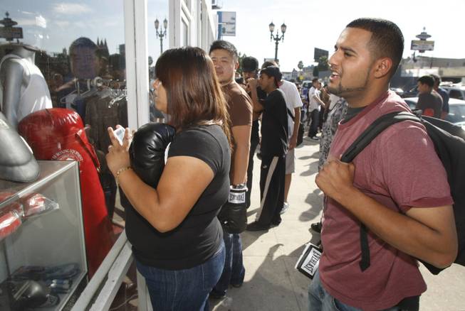Boxing fans try to get a glimpse of WBO welterweight champion Miguel Cotto of Puerto Rico as he works out inside the Pound4Pound Gym in Los Angeles on Tuesday, Nov. 3, 2009. Cotto is scheduled to defend his title against Manny Pacquiao of the Philippines at the MGM Grand Garden Arena on Nov. 14. 