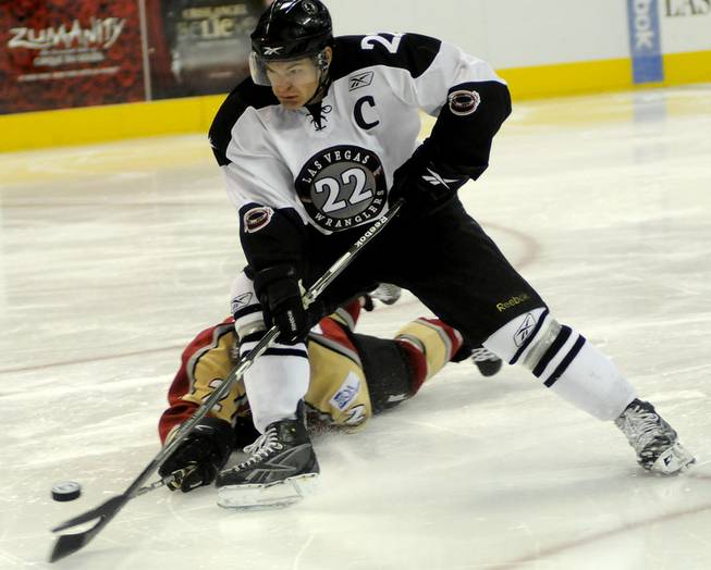 Wranglers forward Chris Neiszner drives toward the net for a shot as Bakersfield defenseman Patrick Prokop dives to chip the puck away during the third period on Thursday night.