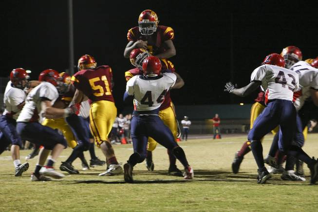 Mona Shield Payne/Special to the Sun..Del Sol running back Dezerick Reed (7) leaps above the line to score a touchdown in the first quarter against Coronado during the Henderson-based Southeast Division championship game Friday at Del Sol.  The Dragons were victorious over the Cougars 46-26.