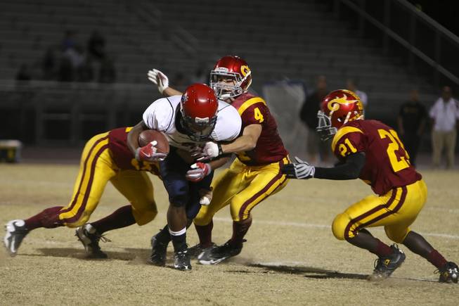 Coronado wide receiver Devon Riley is cornered by Del Sol defenders, from left, Matthew Bogan, Evan Weinstock and Aaron Harwell for a short gain Friday night.