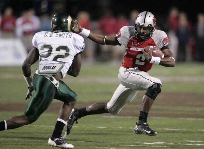 UNLV quarterback Omar Clayton scrambles under pressure from Colorado State defensive back Elijah-Blu Smith during the first half of Saturday's game at Sam Boyd Stadium.