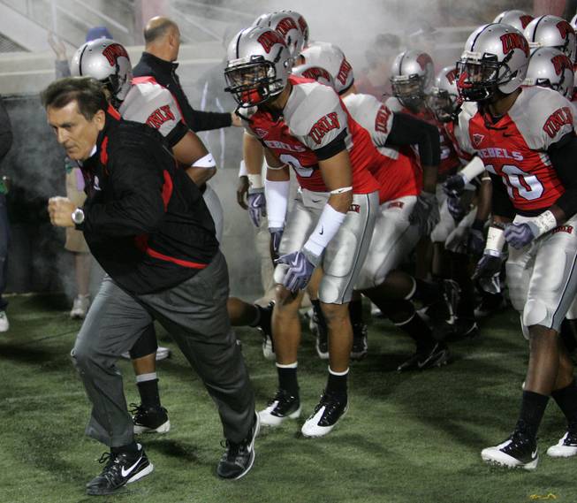 Head coach Mike leads his team out onto the field to take on Colorado St. at Sam Boyd Stadium Saturday.  UNLV came out on top 35-16..