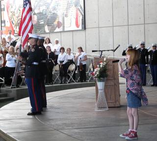 Jessica Vanek, 10, sings the National Anthem while members of the Basic High School Junior ROTC program hold the flag at the Henderson Veterans Day Ceremony Saturday.