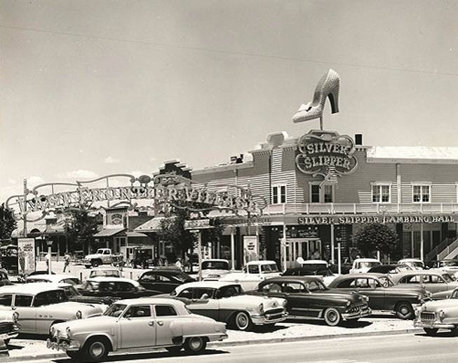 Cars park outside the Silver Slipper Gambling Hall in this photo taken in the late 1950s to early '60s. Its original name is the Golden Slipper Gambling Hall and Saloon because "Silver Slipper" is unavailable at the time. It sits on the Last Frontier Village, right next to the Frontier Hotel.