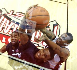 UNLV forward Matt Shaw fights for a rebound with Washburn guard Nate Wallace, left, and William McNeill during their preseason game Tuesday, November 11, 2009.  UNLV won the game 62-52.