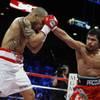 Miguel Cotto (L) takes a punch from Manny Pacquiao during their WBO welterweight title fight Saturday at the MGM Grand Garden Arena.