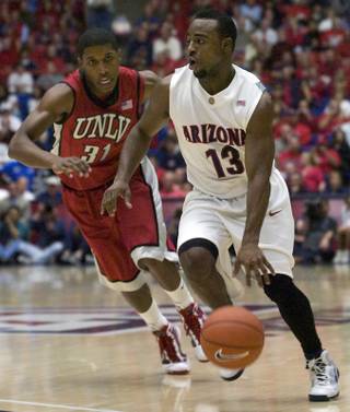 Arizona's Nic Wise (13) drives past the defense of the UNLV's Justin Hawkins (31) during the first half of Wednesday's game in Tucson.