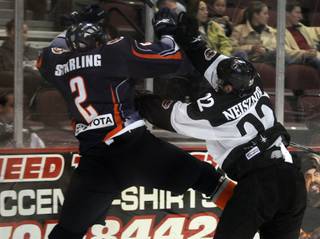 Wranglers captain Chris Neiszner throws Ontario defenseman Chad Starling into the boards during the second period on Saturday night at the Orleans Arena.