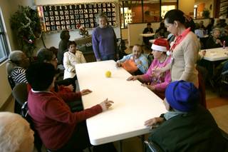 Clients play a dexterity game of rolling a ball around a table at the Nevada Adult Day Healthcare Center Monday, December 29, 2009.