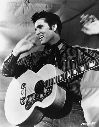 Elvis Presley poses with his Gibson J-200 guitar in an MGM studio publicity photo from the 1950s. Presley will be reunited with Sun Records as part of a licensing agreement between the owner of the historic label and the singer's estate. Sun Entertainment Corp. of Nashville announced the agreement with Elvis Presley Enterprises Inc. Thursday, Oct. 12, 2006. (AP Photo/MGM )