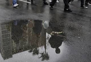 Members of the Sedway Middle School marching band are reflected in a rain puddle as they march in the Martin Luther King Jr. Day parade in downtown Las Vegas Monday, Jan. 18, 2010. 